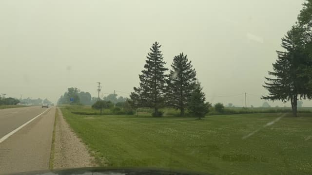 Michigan countryside covered in gray wildfire smoke haze during air quality crisis