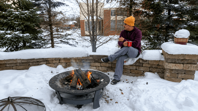 Dr. Vijay Kumar sitting beside a warm fire in a snowy winter landscape reflecting on resilience and hope