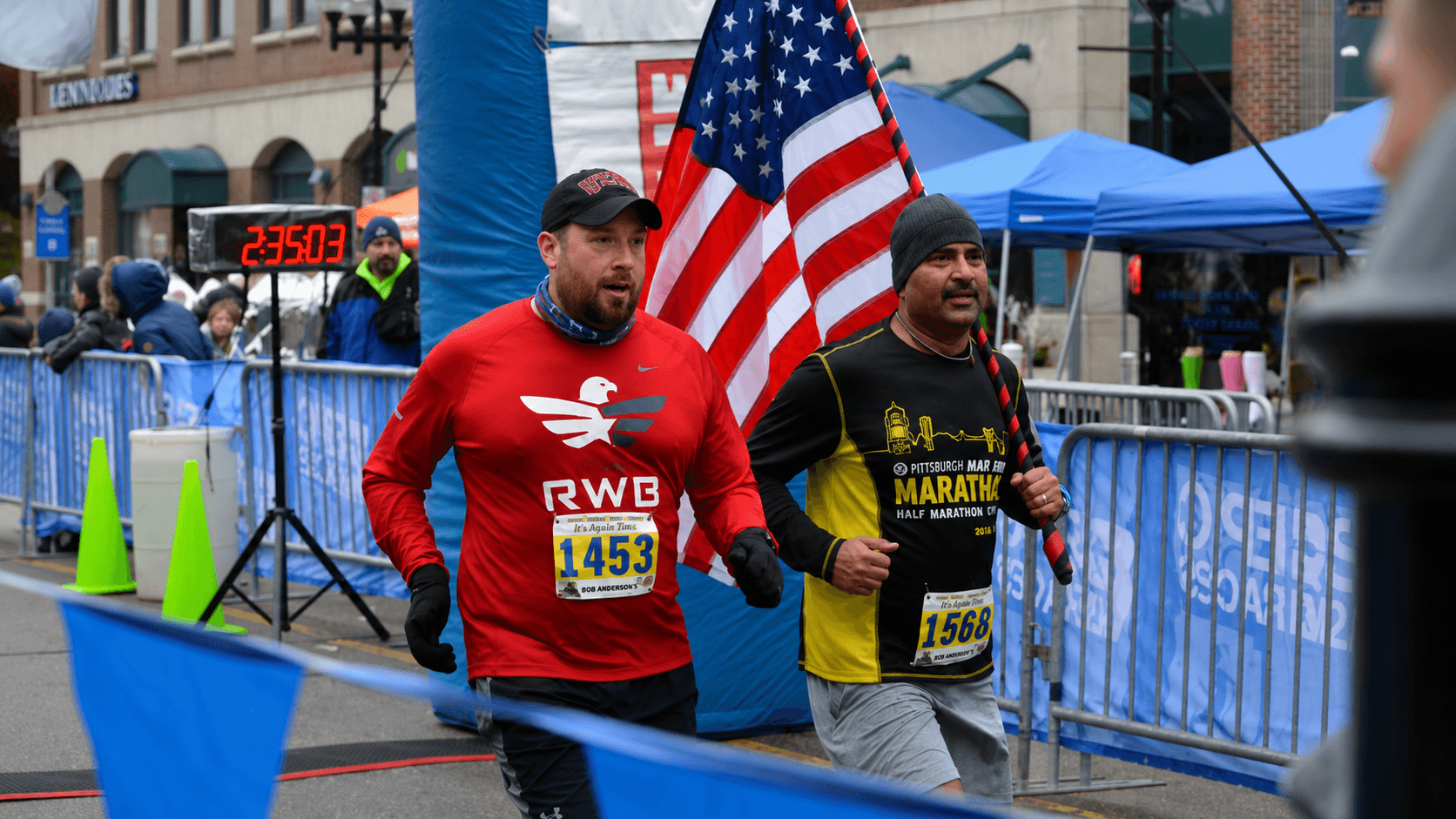 Dr. Vijay Kumar running a marathon while carrying the American flag on a windy day