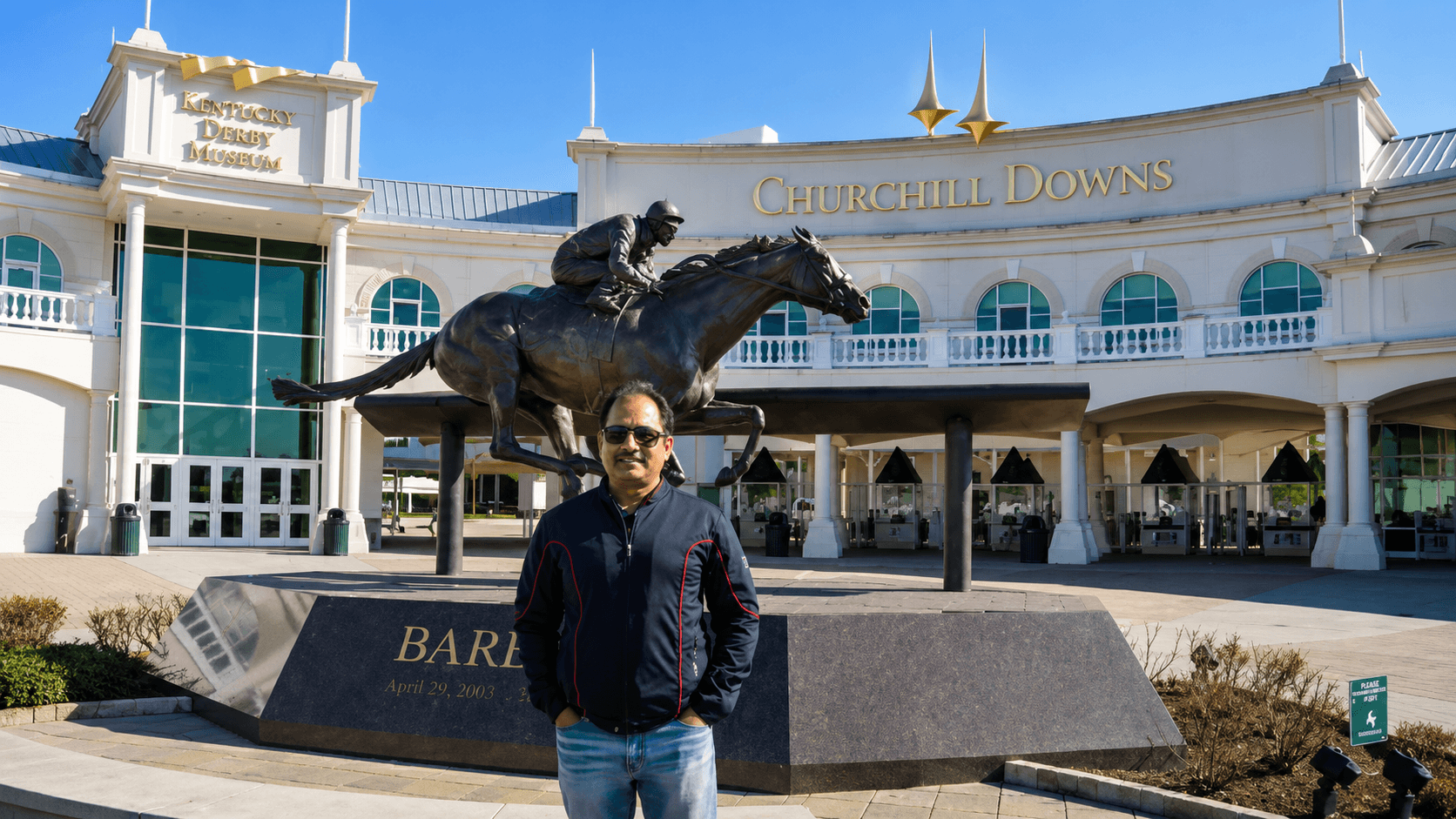 Dr. Vijay Kumar standing beside the Barbaro statue at Churchill Downs during a visit to the Kentucky Derby