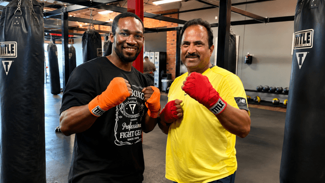 Dr. Vijay Kumar wearing red boxing gloves beside an experienced boxer inside a boxing gym, symbolizing discipline, courage, resilience, and lifelong learning.